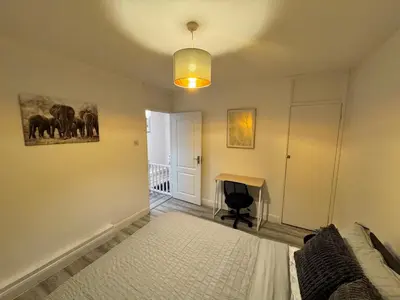 a bedroom with a bed and a desk in it at Modern 3-Bed Flat Stylish Family-Friendly in Moffat