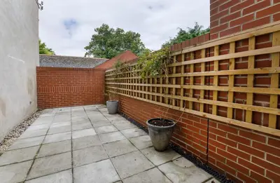 a brick fence with a potted plant on it at 2 On The Green in Moffat