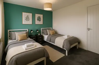 two beds in a room with green walls at Near West Cumbria Hospital in Whitehaven
