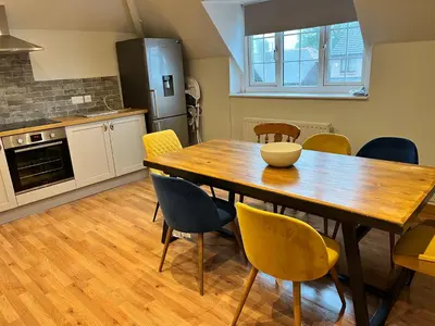 a kitchen with a wooden table and chairs at Wheatsheaf Flat