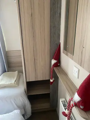 a small room with a small bed and a small room with at surfshack caravan MH19D manor house park in Mawbray