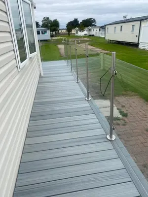 a wooden walkway on the side of a house at surfshack caravan MH19D manor house park in Mawbray