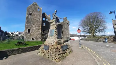a statue of a man sitting on top of a building at Wee Newton in Twynholm