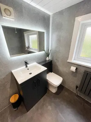 a bathroom with a sink and a toilet and a mirror at The Retreat, Cosy 1 Bed Cottage, Town Centre Location in Kirkcudbright