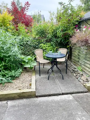 two chairs and a table in a garden at The Retreat, Cosy 1 Bed Cottage, Town Centre Location in Kirkcudbright
