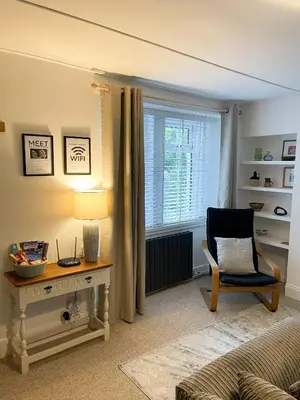 a living room with a desk and a chair and a window at The Retreat, Cosy 1 Bed Cottage, Town Centre Location in Kirkcudbright