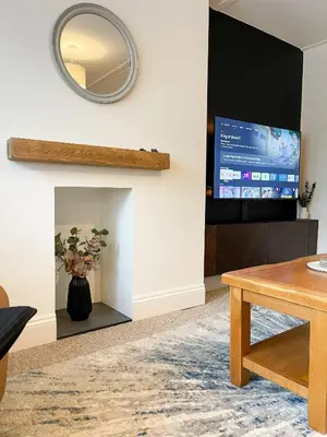 a living room with a fireplace and a tv at The Retreat, Cosy 1 Bed Cottage, Town Centre Location in Kirkcudbright