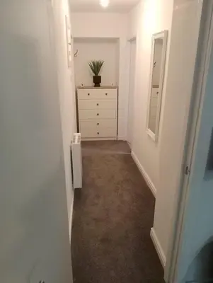 a hallway with a dresser and a chest of drawers at Coach House Apartment - Sleeps 2 in Whitehaven