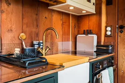 a kitchen with wood paneling and a sink and a stove at Redwood in Moffat