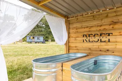 a bath tub sitting inside of a wooden cabin at Quercus & Redwood - Sleeps 4 in Moffat