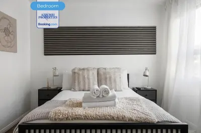 a bedroom with a bed with two towels on it at Cozy 4-Bedrooms House By Azzurri Properties Short Lets & Serviced Accommodation London With Private Garden, Wi-Fi in Moffat