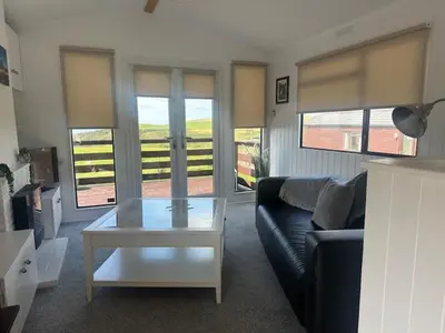 a living room with a couch and a coffee table at Bowmore 7 - Stunning Sea Views, Farm Stay in Stranraer
