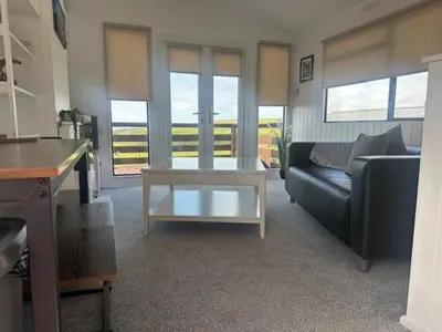 a living room with a couch and a coffee table at Bowmore 7 - Stunning Sea Views, Farm Stay in Stranraer