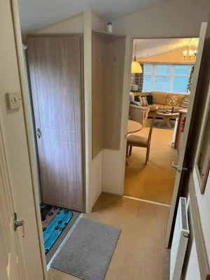 a hallway with a door open to a living room at The West Lakes Caravan in Lamplugh