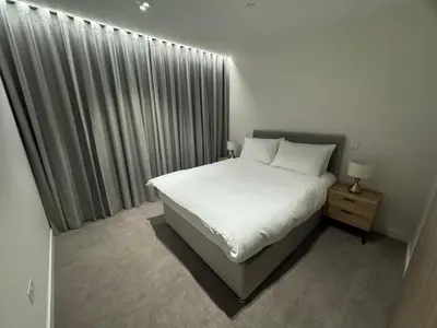 a bedroom with a white bed and a window at Modern Serviced Apartment in Kings Cross Central London in Moffat