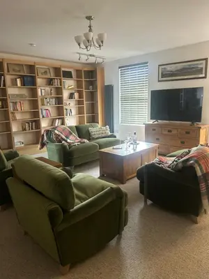 a living room with green couches and a tv at Richmond, Tithebarn St, Keswick in Keswick