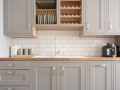 a kitchen with white cabinets and a sink at Richmond, Tithebarn St, Keswick in Keswick