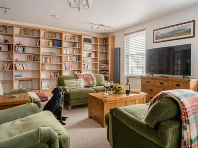 a living room with a dog sitting in front of a book shelf at Richmond, Tithebarn St, Keswick in Keswick