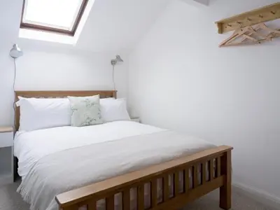 a bedroom with a bed with white sheets and pillows at Richmond, Tithebarn St, Keswick in Keswick