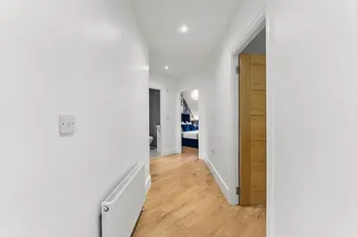 a hallway with white walls and a wooden door at Modern 2-Bed Apartment in Canterbury City Centre in Moffat