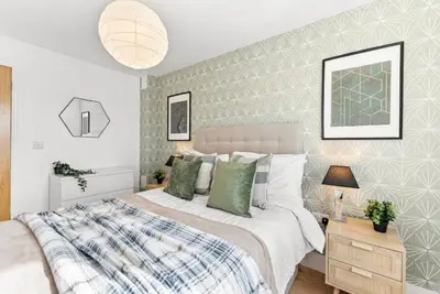 a bedroom with a large bed with green pillows at Modern 2-Bed Apartment in Canterbury City Centre in Moffat