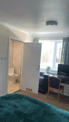 a bedroom with a bed and a desk and a window at QueensBerry accommodation in Annan