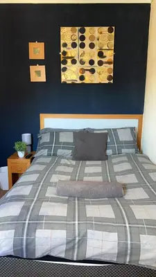 a bedroom with a bed with a blue wall at QueensBerry accommodation in Annan