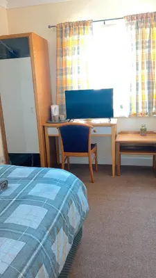 a bedroom with a desk and a bed and a desk at QueensBerry accommodation in Annan
