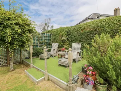 a garden with two chairs and a table and some plants at Learig Lodge in Girvan