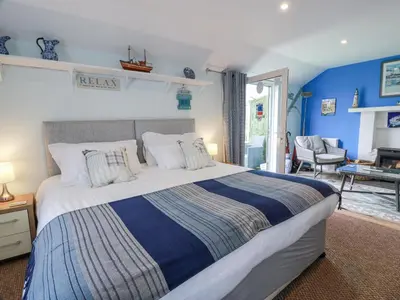 a bedroom with a large bed with blue walls at Learig Lodge in Girvan