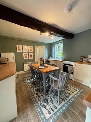a kitchen with a wooden table and chairs at 1 Laithes Cottages in Skelton