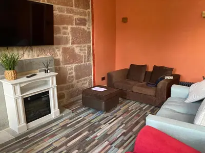 a living room with a couch and a fireplace at The Tartan Sheep in Kilmarnock