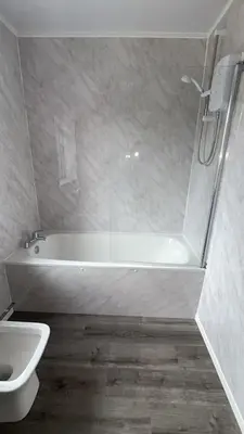 a bathroom with a tub and a toilet and a sink at QueensBerry accommodation in Annan