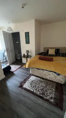 a bedroom with a bed and a rug on the floor at QueensBerry accommodation in Annan