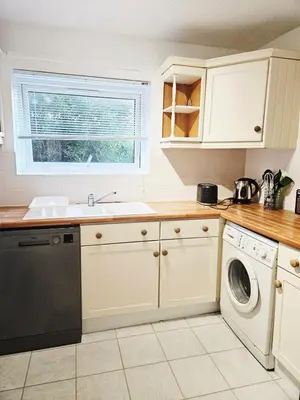 a kitchen with a sink and a washing machine at Egremont 2-Bed Flat Near Lake District with Free Parking & Wi-Fi in Egremont