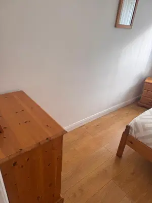 a room with a bed and a wooden table at Egremont 2-Bed Flat Near Lake District with Free Parking & Wi-Fi in Egremont