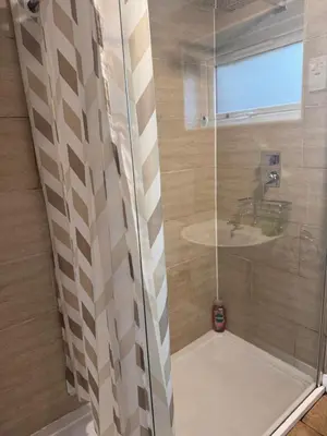 a shower with a glass door and a sink at Egremont 2-Bed Flat Near Lake District with Free Parking & Wi-Fi in Egremont