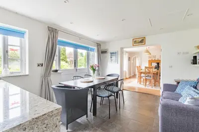 a dining room and living room with a table and chairs at St Mary's House by Keepers Cottages in Moffat