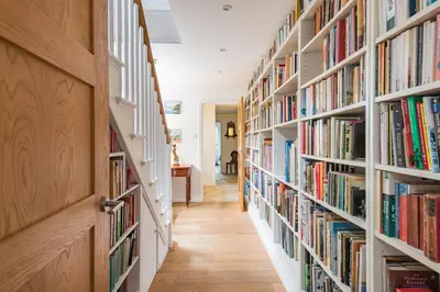 a hallway with bookshelves filled with books at St Mary's House by Keepers Cottages in Moffat