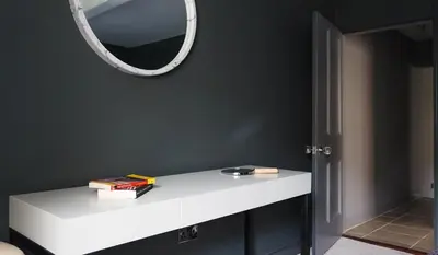 a white counter with a mirror on a black wall at Gorgeous Georgian townhouse in Moffat