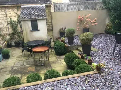 a patio with a table and chairs and plants at Gorgeous Georgian townhouse in Moffat
