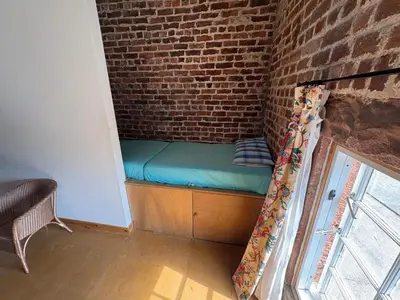 a small room with a bed in a brick wall at Hillside Farm in Carlisle