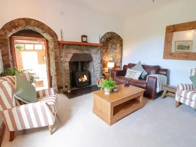 a living room with couches and a fireplace at Balsaggart Farm in Maybole