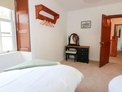 a bedroom with a bed and a dresser and a window at Balsaggart Farm in Maybole