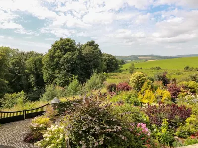 a garden with colorful flowers on a path at Balsaggart Farm in Maybole