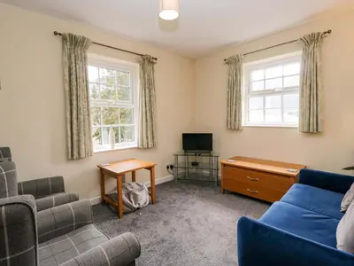 a living room with a blue couch and a tv at Buckbarrow in Seascale