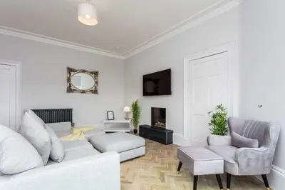 a living room with a couch and two chairs at The Bay Suite - Donnini Apartments in Troon