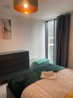 a bedroom with a bed with a dresser and a window at The Bank Tower in Moffat