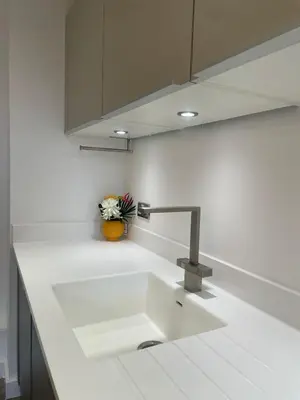 a kitchen counter with a sink and a vase of flowers at The Bank Tower in Moffat