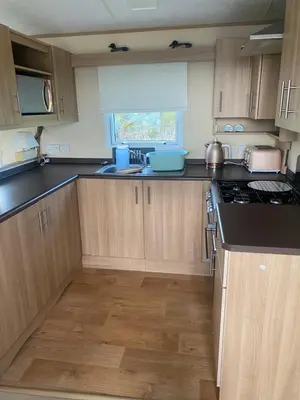 a kitchen with wooden cabinets and a counter top at Turnberry holiday park in Turnberry